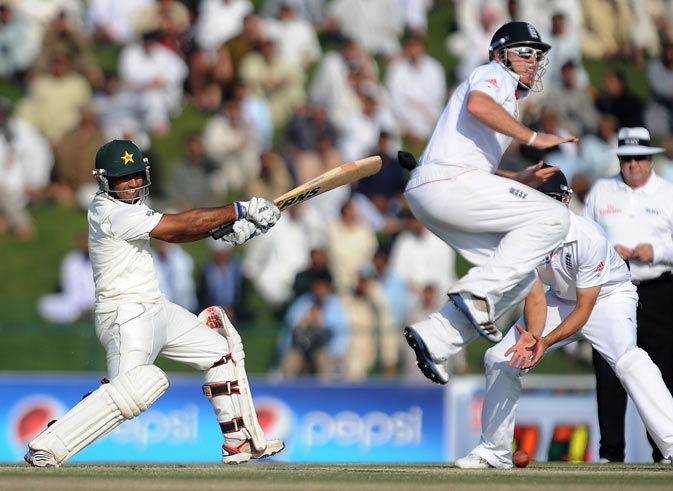 Pakistan's Asad Shafiq (L) plays a shot as England's Ian Bell (R) jumps in the air during the third day of the second Test cricket match. ? AFP Photo