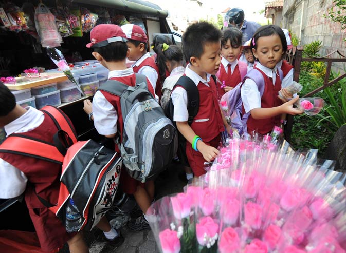 Indonesian students from a catholic school buy flowers to celebrate Valentine's Day in Denpasar on Bali island. Valentine's Day is a holiday observed on February 14 honoring one or more early Christian martyrs named Saint Valentine. – AFP Photo.