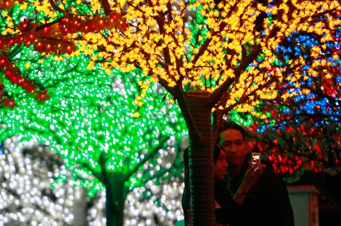 A Muslim couple takes pictures at the "Million Lights, Million Hearts" display ahead of Valentine's Day celebrations at Shah Alam commercial hub i-City, outside Kuala Lumpur. Islamic authorities in Muslim-majority Malaysia have been conducting raids on Valentine's Day after an edict was issued in 2005 banning Muslims from celebrating the occasion, considered a Western celebration that could erode Muslim's faith. – Reuters Photo.