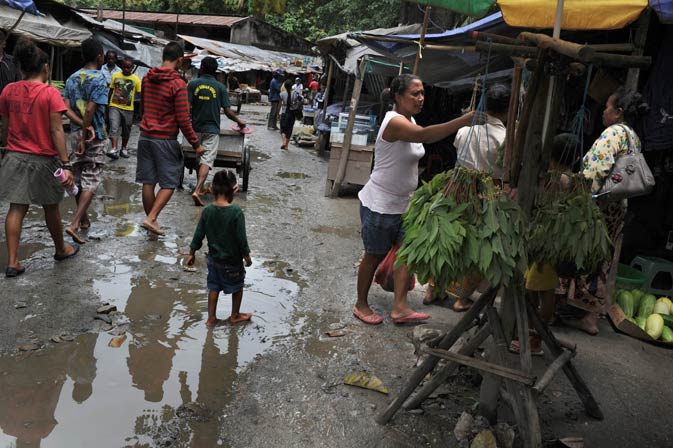 A child walks in a mud puddle at Dili's traditional market ahead of the presidential elections contested by 12 candidates. A decade after independence East Timor is restive for change, voting Saturday in the second presidential polls as a free country and hoping that an energy-fuelled bonanza will lift this tiny Southeast Asian nation out of poverty and chronic instability. ? AFP Photo