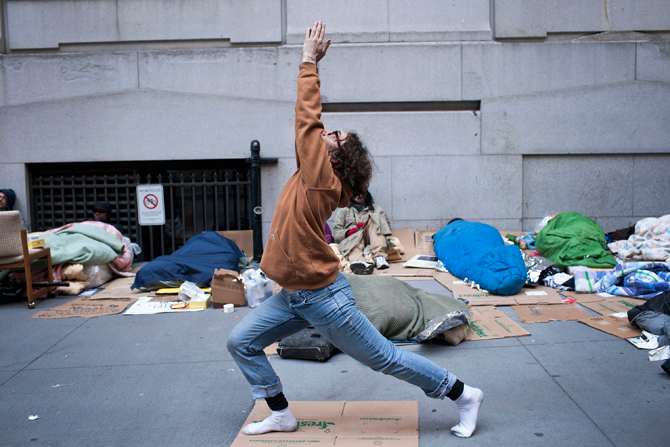 Occupy Wall Street protester Ray Leone practices yoga after sleeping at the corner of Wall Street and Nassau Street, across the street from the New York Stock Exchange, in the Financial District in New York April 12, 2012. – Reuters Photo.