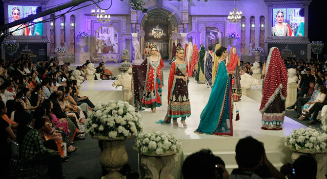 In this Saturday, April 14, 2012 photo, Pakistani models present creations by designer Zainab Sajid, during Bridal Couture Week in Karachi, Pakistan. ? Photo by AP