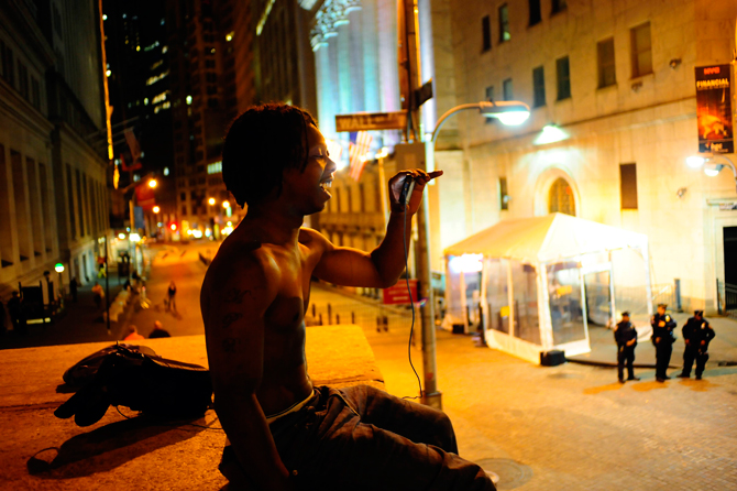 Sean Gregg, a member of the Occupy Wall Street movement, records a live podcast as he sits on Federal Plaza across from the New York Stock Exchange in New York April 15, 2012. – Reuters Photo.
