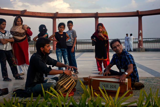 A Pakistani local singer performs for his living at Lake View park on the outskirts of Islamabad, Pakistan. ? Photo by AP