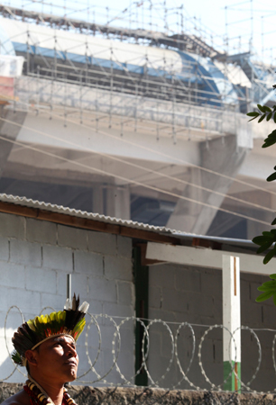 A Brazilian native Indian stands inside the former Indian Museum, in front of renovation works for Maracana stadium in Rio de Janeiro.