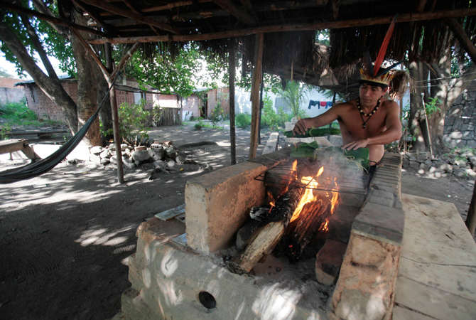 Brazilian native Indian Afonso Chamacari cooks a fish inside the former Indian Museum in Rio de Janeiro.