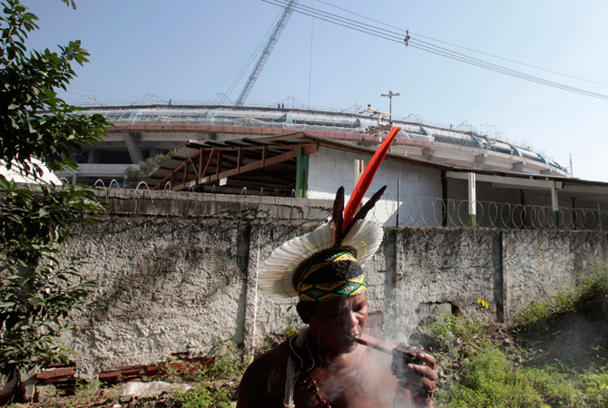 A Brazilian native Indian smokes inside the former Indian Museum in front of renovation works for Maracana stadium in Rio de Janeiro.