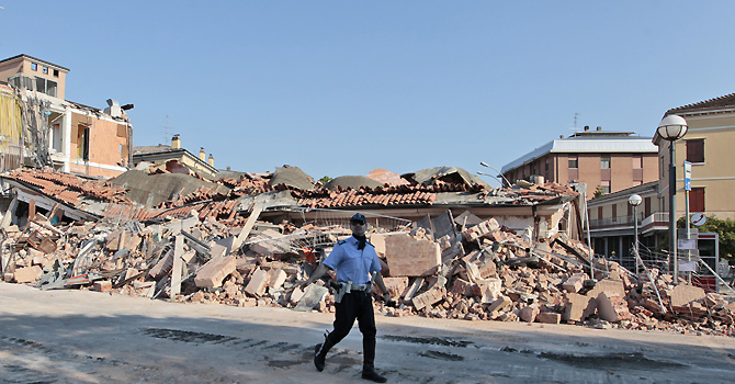 Italy Quake A local police officer walks past collapsed buildings in Cavezzo, Italy, Tuesday, May 29, 2012. A magnitude 5.8 earthquake struck the same area of northern Italy stricken by another fatal tremor on May 20. (AP Photo/Gregorio Borgia)