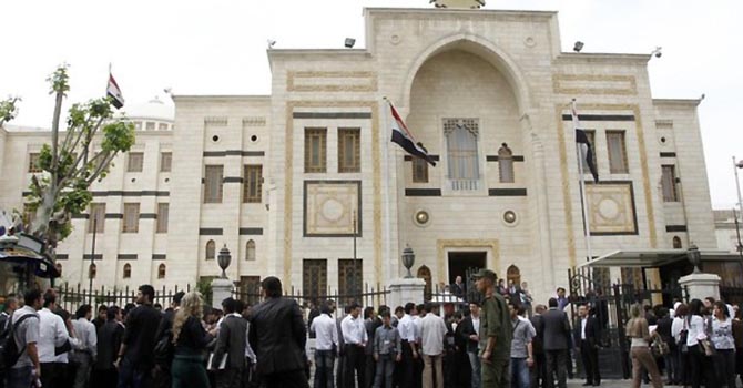 Youths gather in front of the Syrian parliament building in Damascus