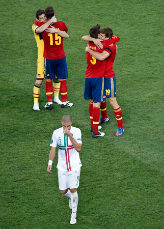 Portugal's Pepe leaves the pitch as Spanish players celebrate winning the Euro 2012 semi-finals. ? Photo by AP