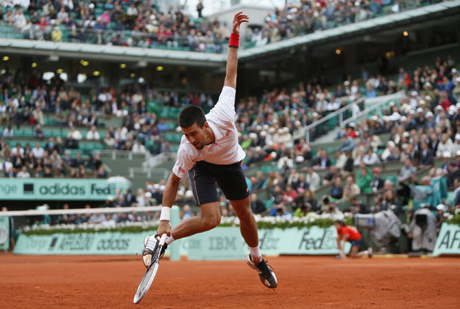 Serbia's Novak Djokovic falls as he plays with France's Jo-Wilfried Tsonga during their Men's Singles Quaterfinals tennis match. ? Photo by AFP