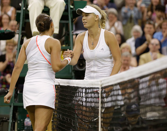Caroline Wozniacki of Denmark, right, congratulates Tamira Paszek of Austria after she lost their first round women's singles match. – Photo by AP