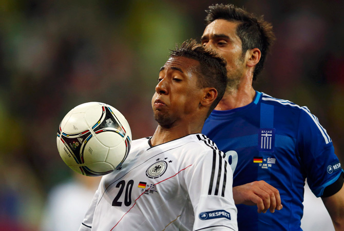Germany's Jerome Boateng (Left) is challenged by Greece's Sokratis Papastathopoulos during their Euro2012 quarter-final soccer match.