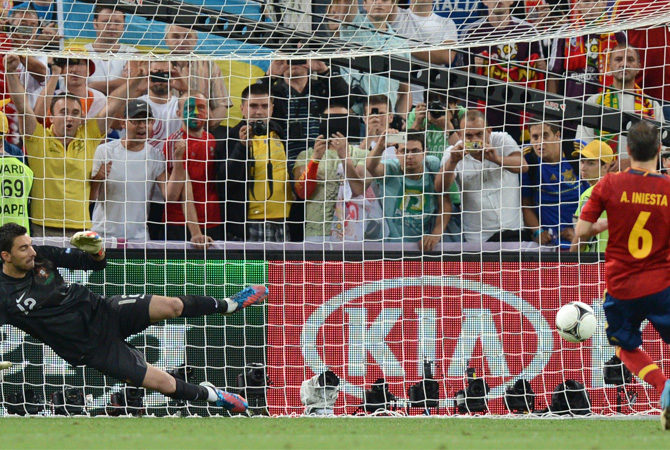 Spanish midfielder Andres Iniesta (Right) scores a penalty against Portuguese goalkeeper Rui Patricio during the penalty shoot-out. ? Photo by AFP