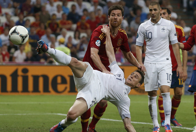 France's Laurent Koscielny is challenged by Spain's Xabi Alonso. ? Photo by Reuters