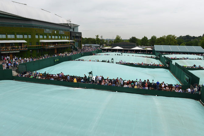 Covers on the outside courts during a rain shower on day three of the 2012 Wimbledon Championships tennis tournament. – Photo by AFP