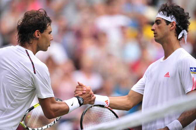Spain's Rafael Nadal shakes hands with Brazil's Thomaz Bellucci (R) after his first round men's singles victory. ? Photo by AFP