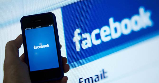 facebook app The photo shows a view of a phone displaying the Facebook app's splash screen in front of the login page in Washington, DC. – AFP