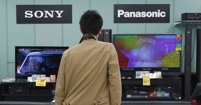 OLED A man looks at Sony and Panasonic TV sets at an electronics shop in Tokyo. – Reuters
