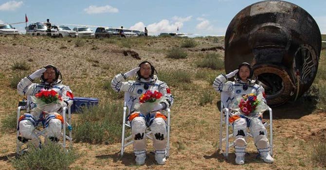 China Chinese astronauts Jing Haipeng (C), Liu Wang (L) and Liu Yang, China's first female astronaut, salute in front of the re-entry capsule of China's Shenzhou 9 spacecraft. – Reuters