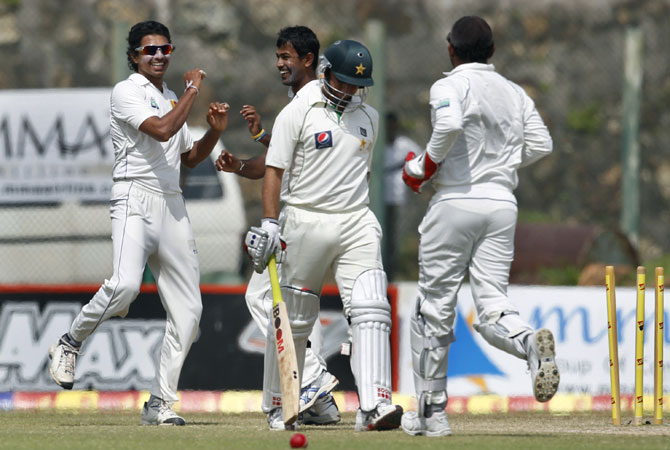 Sri Lanka's Suraj Randiv, left celebrates the dismissal of Pakistan's batsman Saeed Ajmal, second right with Nuwan Kulasekara, second left. -Photo by AP