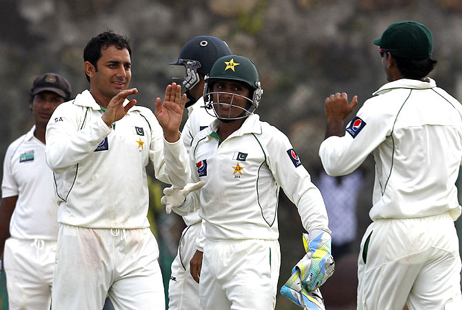 Ajmal (2L) celebrates with teammates after the dismissal of Sri Lanka cricketer Tillakaratne Dilshan (R). -Photo by AP