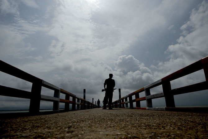 A Bangladeshi Border Guard keeps watch on a jetty on the Naf river in Teknaf. Bangladesh refused three more boatloads of Rohingya Muslims fleeing sectarian violence in Myanmar, officials said, despite growing calls for the border to be opened. -Photo by AFP