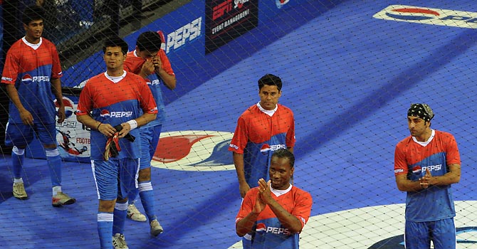FBL-IND-T20-DROGBA International football player from the Ivory Coast, Didier Drogba (2R), gestures before the start of an exhibition match in New Delhi on June 17, 2012. Drogba is in the city for the grand finale of the Pepsi T20 football tournament. AFP PHOTO/ SAJJAD HUSSAIN