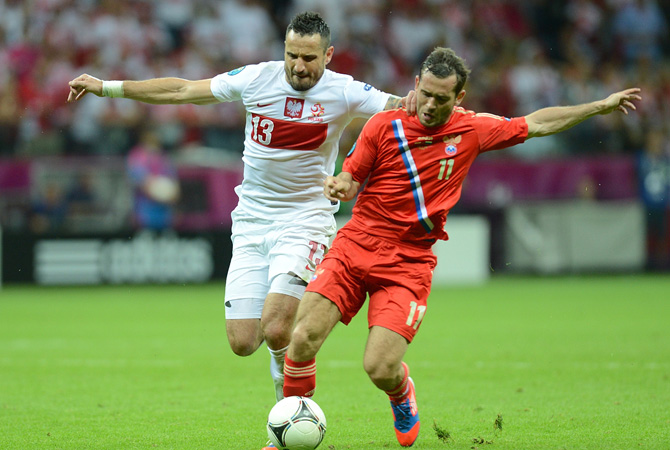 Polish defender Marcin Wasilewski vies with Russian forward Aleksander Kerzhakov during the Euro 2012 championships football match Poland vs Russia at the National Stadium in Warsaw.