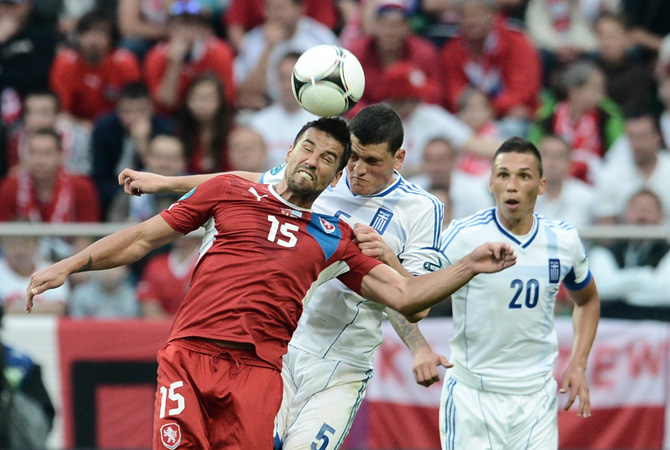 Czech forward Milan Baros and Greek defender Kyriakos Papadopoulos head the ball during the Euro 2012 championships football match Greece vs Czech Republic at the Municipal Stadium in Wroclaw.