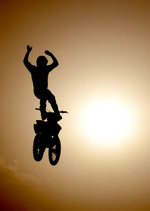 A stunt rider of Red Bull X-Fighters, silhouetted against the sun, performs during a show in New Delhi, India. ? Photo by AP