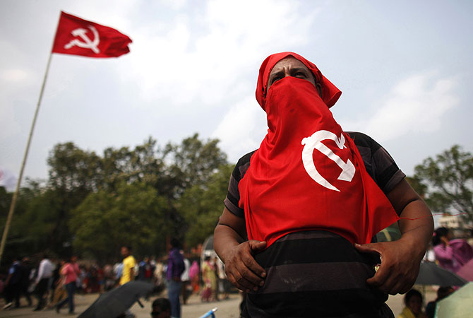 A supporter of establishment faction of the Unified Communist Party of Nepal (Maoist) listen to the speech given by the party leaders during the mass rally in Kathmandu, Nepal. -Photo by AP