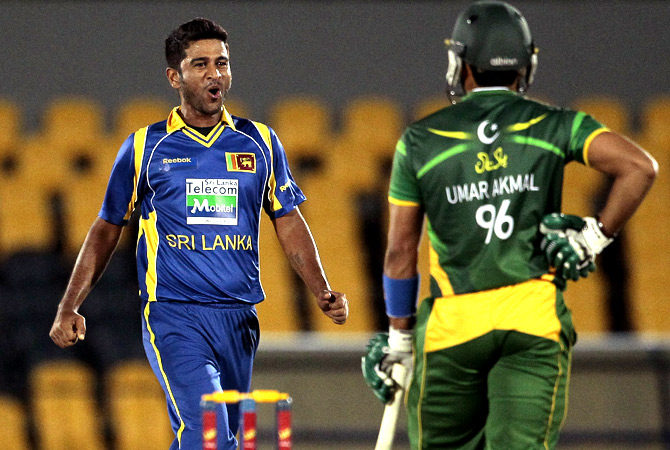 Sri Lankan bowler Kaushal Lokuarachchi, left, celebrates the dismissal of Pakistan's batsman Umar Akmal. -Photo by AP