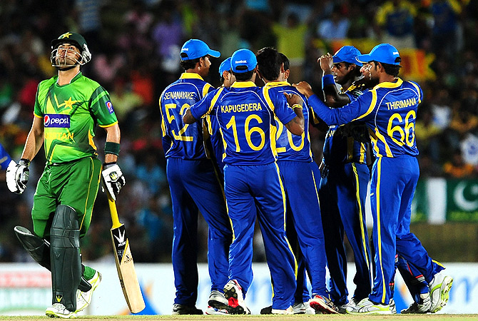 Pakistan cricketer Ahmed Shehzad (L) reacts after being dismissed. -Photo by AFP