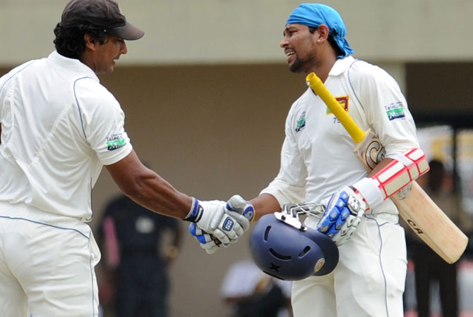 Tillakaratne Dilshan (R) is congratulated by teammate Kumar Sangakkara (L) after scoring a half-century. -Photo by AFP