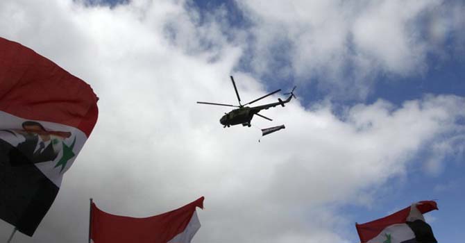 A helicopter flies over a rally of supporters of Syria's President Bashar al-Assad at Umayyad square in Damascu