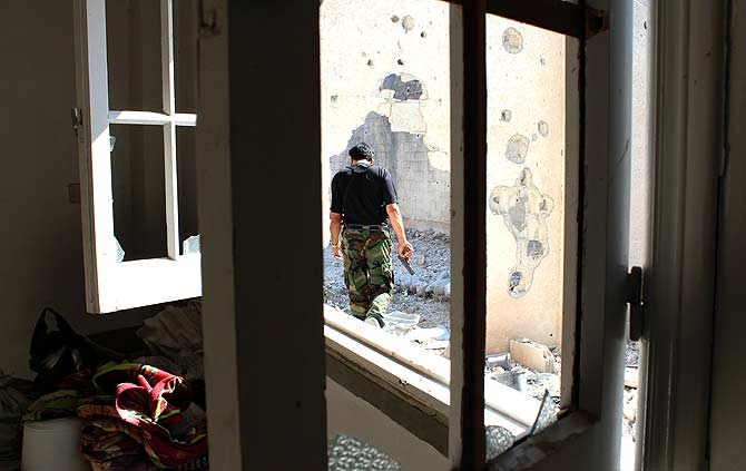 A handout image released by the Syrian opposition's Shaam News Network allegedly shows a member of the Free Syrian Army (FSA) holding a gun as he walks in the restive central city of Homs? Photo by AFP
