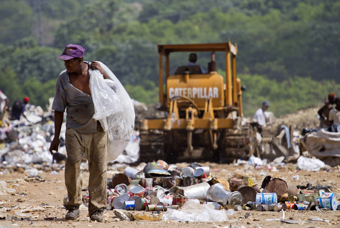 A scavenger collects plastics and other useful things at a dump in Haina, a town in southern Dominican Republic, on the eve of World Environment Day. ? Photo by AFP