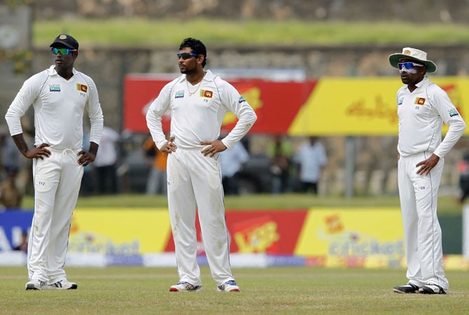 Sri Lanka's captain Mahela Jayawardene (R), vice-captain Angelo Mathews (L) and Tillakaratne Dilshan look at the third umpire box while they react after Pakistan's batsman Younis Khan was adjudged not out to a catch by Dilshan. -Photo by Reuters