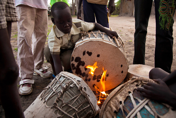 A boy tightens the hide on his drum before church services at the Presbyterian Church in Pibor. – Photo by Reuters