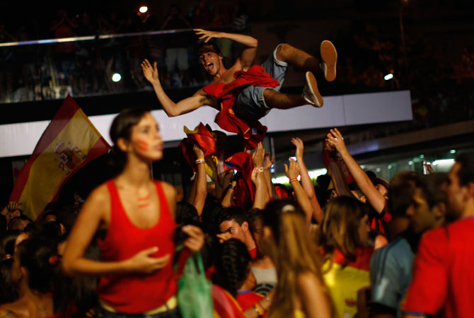 A fan (top) is tossed in the air by fellow Spain supporters as they celebrate Spain's victory over Italy in their Euro 2012. ? Photo by Reuters