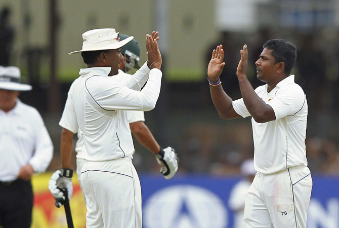 Sri Lanka's Rangana Herath (R) celebrates taking the wicket of Pakistan's Younis Khan with Sri Lanka's captain Mahela Jayawardene during the second day of second test match in Colombo July 1, 2012. ? Photo Reuters