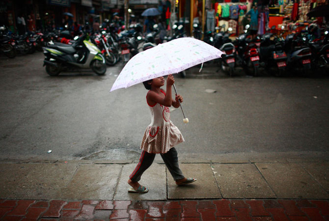 A girl walks with her umbrella along a street in Kathmandu. The monsoon season in Nepal typically lasts from June to August. ? Photo by Reuters