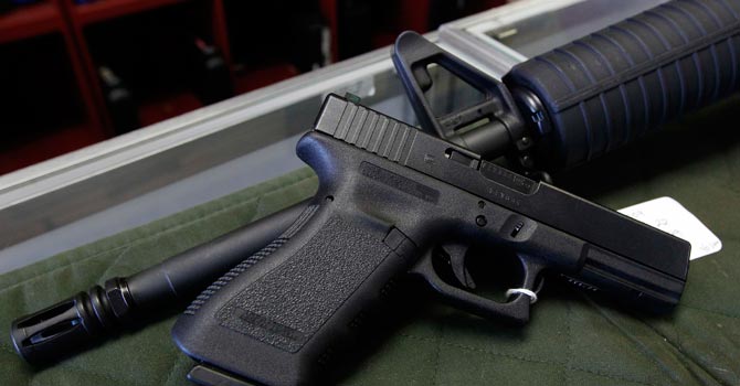 A Glock 22 pistol is seen laying on a Palmetto M4 assault rifle at the Rocky Mountain Guns and Ammo store. — AP Photo