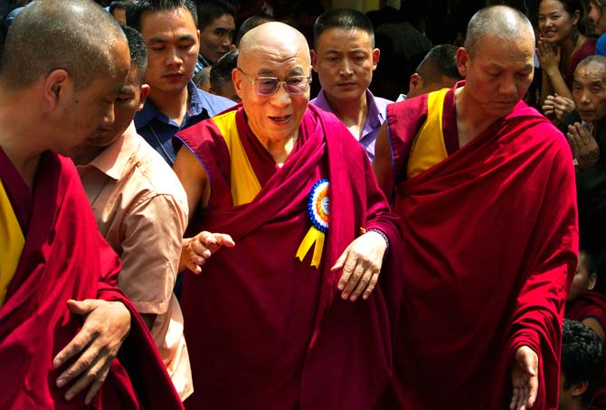 Tibetan spiritual leader the Dalai Lama, centre, is escorted by Tibetan monks as he leaves Tsuglakhang temple in Dharmsala. ? Photo by AP