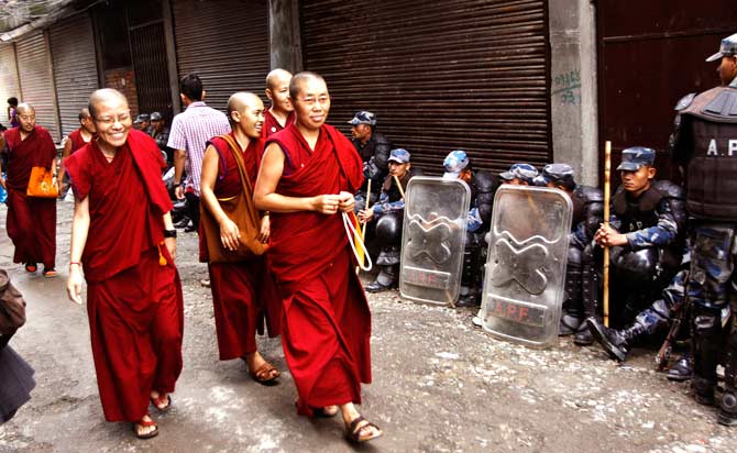 Tibetan nuns arrive at Chusang monastery as Nepalese police officers guard in Katmandu. ? Photo by AP