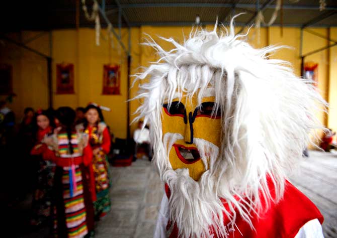 A masked dancer with gets ready to perform a mask dance. ? Photo by Reuters