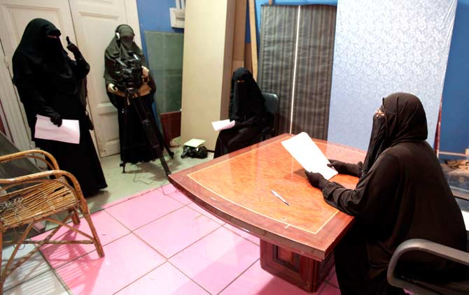 A program is filmed in a studio of a new TV channel which is being managed and run exclusively by women who wear the full veil, to be launched this weekend, in Cairo on the first day of Ramazan. ? Photo by Reuters