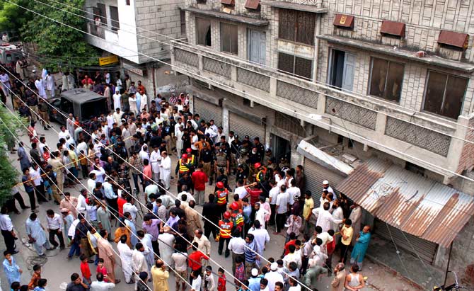 Residents and rescuers gather outside the police hostel.? Photo by AFP