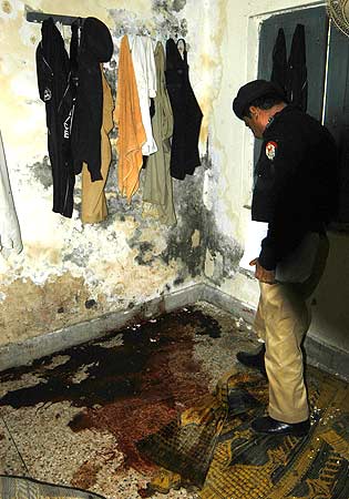 A Pakistani police officer inspects the attack site at the police hostel. ? Photo by AFP